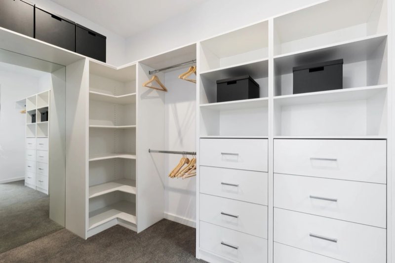 Custom white walk-in closet with open shelving and drawers