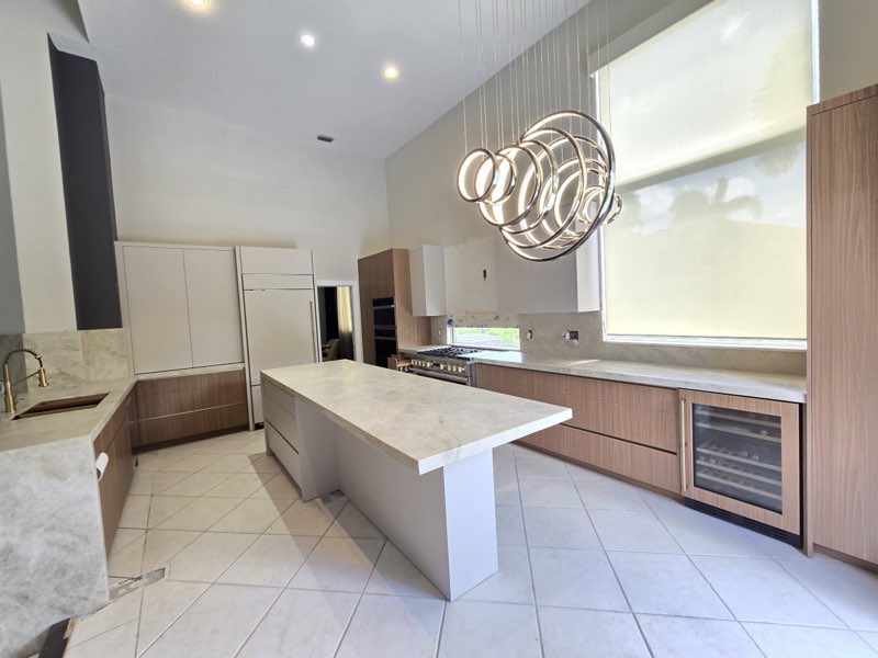 Modern kitchen with wood cabinets and a marble waterfall island